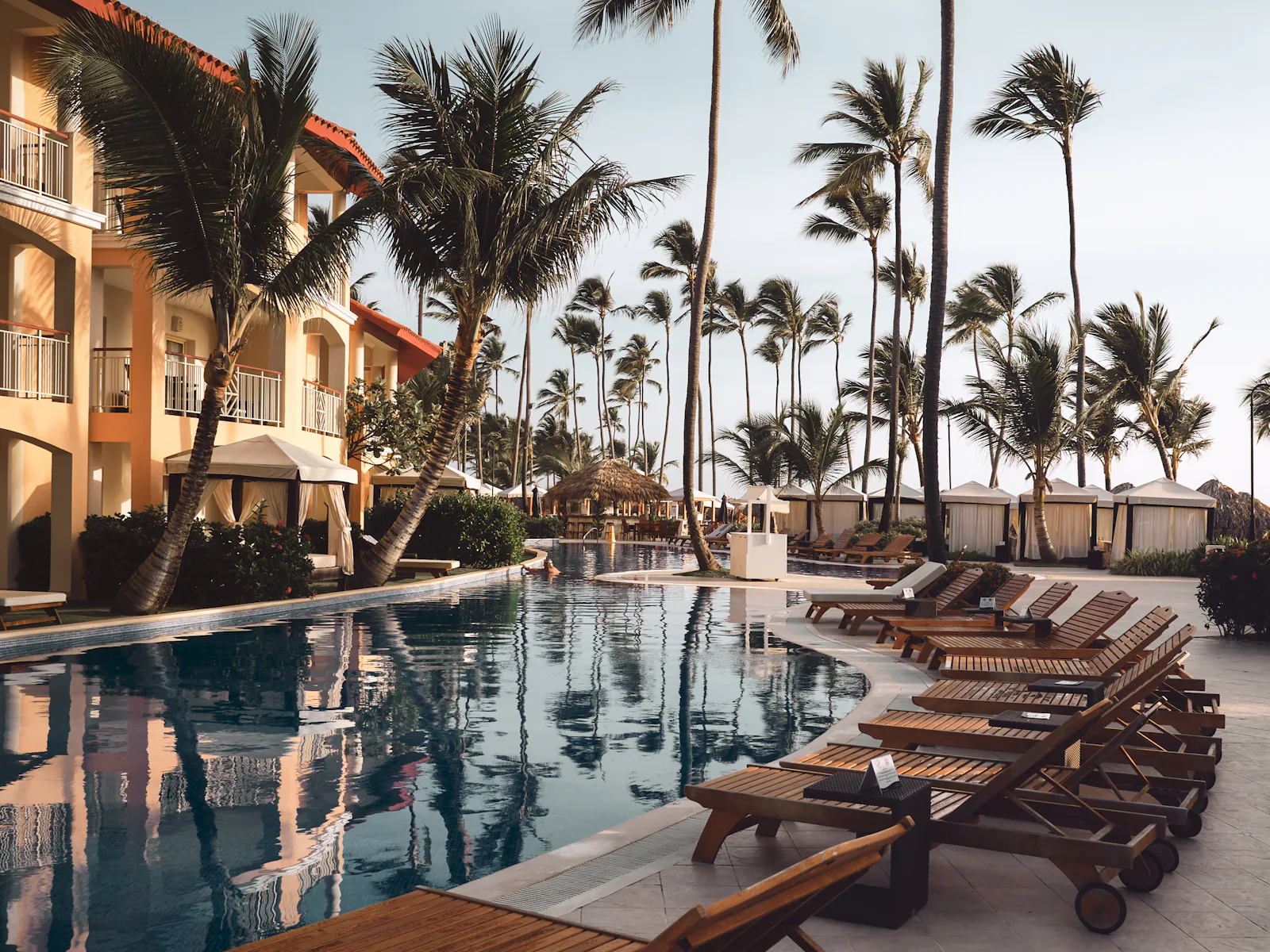Piscina y tumbonas entre palmeras en Punta Cana